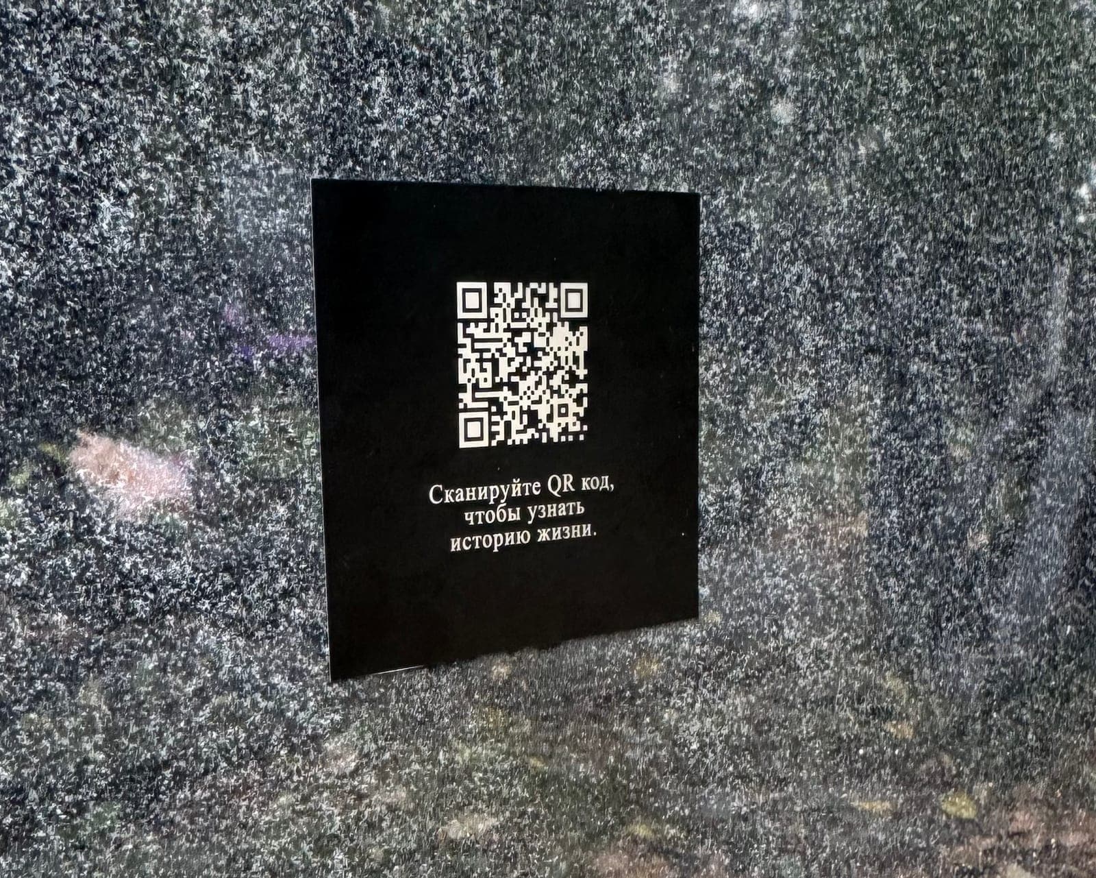 Чёрная алюминиевая табличка с надписью и QR‑кодом крупным планом