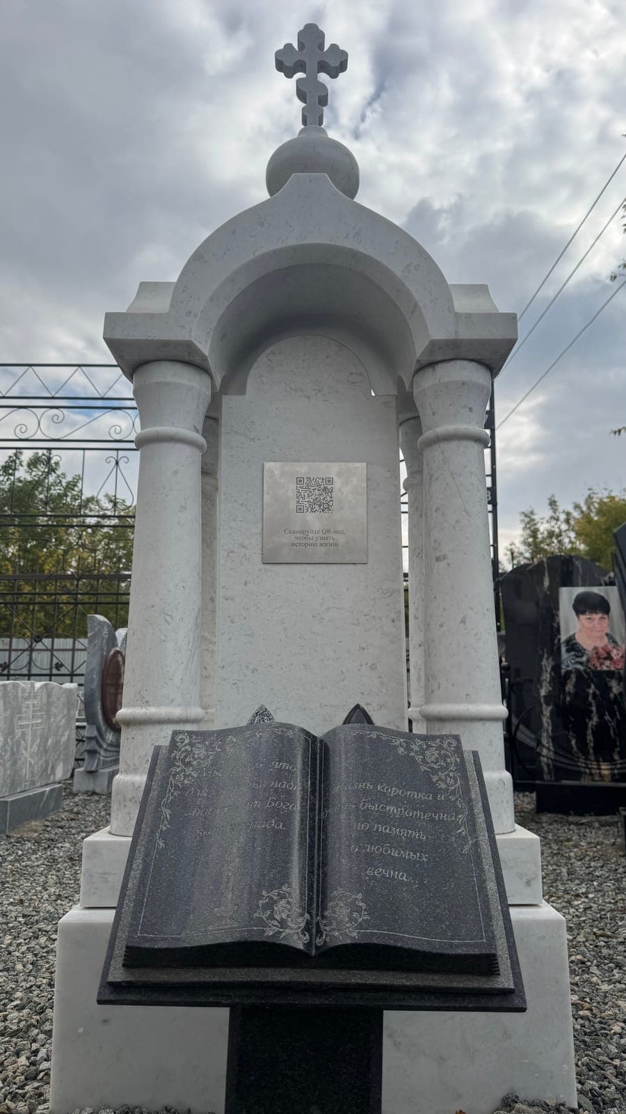 Стальная табличка на белом памятнике в виде часовни